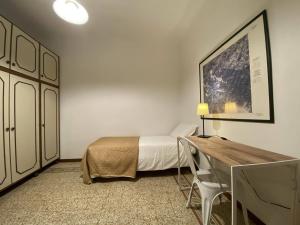 a bedroom with a bed and a desk and a table at Accademia Apartment in Florence
