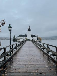a bridge leading to a lighthouse on a body of water at Traunsee Design Apartment for 2 People in Gmunden