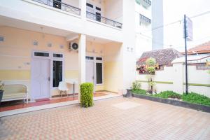 a courtyard of a building with a bench and a building at RedDoorz Syariah at Aura Homestay in Ponorogo