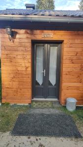 a wooden building with a door with a sign on it at La tanière du lac d Aiguebelette in Lepin-le-Lac