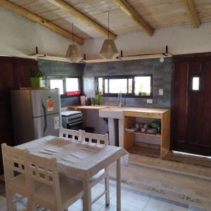 una cocina con una mesa y un refrigerador en Cabaña Los Algarrobos, en Villa Icho Cruz