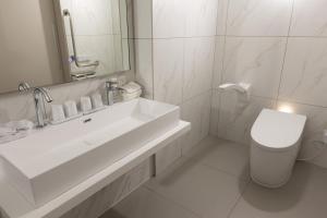 a white bathroom with a sink and a toilet at Hotel Rose Garden Shinjuku in Tokyo