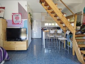 a living room with a tv and a bar with stools at Cabaña Los Pinos in Villa Icho Cruz