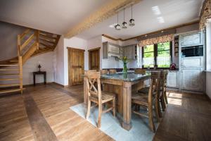 a kitchen with a wooden table and some chairs at DWÓR U PAPUGA in Ruciane-Nida