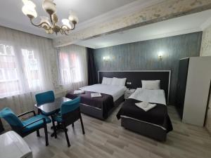 イスタンブールにあるLuxury grand bazaar suitesのベッドルーム1室(ベッド2台、テーブル、椅子付)