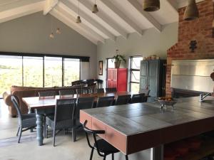 a dining room with tables and chairs and a kitchen at Pezula Holiday in Knysna