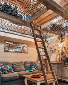 a loft bed in a living room with a couch at Ojcowski Zakątek-uroczy domek do wynajęcia in Wola Kalinowska