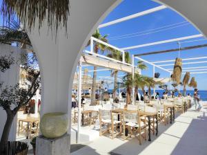 un restaurante en la playa con mesas y sillas en Apartamento Moreras del Saladar, en Jávea