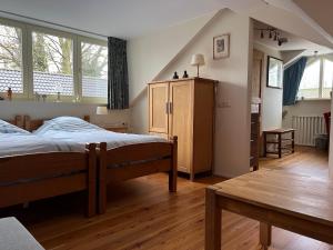 a bedroom with a bed and a table and windows at Bed en Breakfast De Kees in Eersel