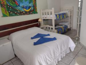 a bedroom with a bed with blue towels on it at Pousada do Rei in Ubatuba