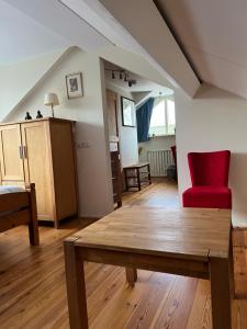 a living room with a table and a red chair at Bed en Breakfast De Kees in Eersel