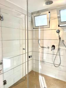 y baño con ducha y puerta de cristal. en POOL GYM AND BEACH FRONT 3 BEDROOMS LUXURY TEL AVIV APARTMENT, en Tel Aviv