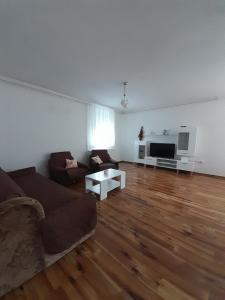 un soggiorno con un divano e una TV di Kuća za odmor Mirna a Gospić