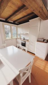 a white kitchen with a white table and chairs at CharmeRooms Villa Moroni La Depandance in Stezzano