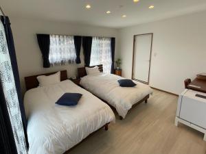 座間味的住宿－Dining & Stay 38 Miyahira，一间卧室配有两张床和镜子