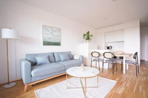 sala de estar con sofá azul y mesa en Bright & Wonderful Apartment at Oberlaa Therme, en Viena