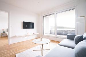 Sala de estar blanca con sofá y mesa en Bright & Wonderful Apartment at Oberlaa Therme, en Viena