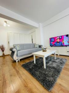 uma sala de estar com um sofá e uma mesa em Luxury Apartment with Sunset View Palas em Iaşi
