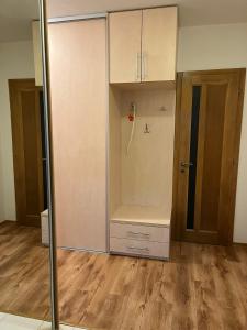 a room with a closet and a door and wooden floors at Apartmán Zuzu FREE Parking in Trenčín