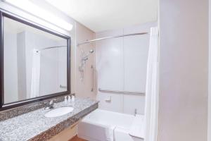 ein weißes Badezimmer mit einem Waschbecken und einem Spiegel in der Unterkunft Baymont by Wyndham Wheeler in Wheeler