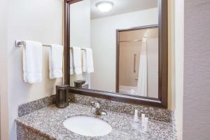 a bathroom with a sink and a mirror and towels at Baymont by Wyndham Wheeler in Wheeler