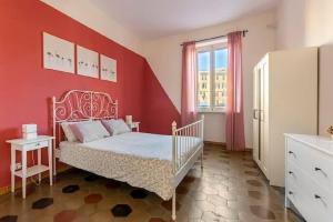 um quarto com uma cama e uma parede vermelha em IN ROME IN LOVE IN BIKE em Roma