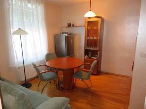 - un salon avec une table, des chaises et un réfrigérateur dans l'établissement Peony, à Rogaška Slatina