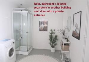 a bathroom with a shower and a washing machine at Rustik gäststuga med lantlig känsla nära Örebro city in Örebro