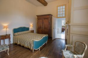 a bedroom with a bed and a chair in it at Le Logis d'Equilly in Équilly