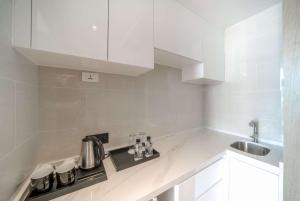 a white kitchen with a stove and a sink at Wyndham La Vita Rawai Phuket in Rawai Beach