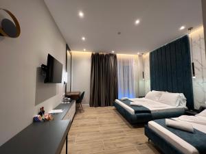 una camera d'albergo con 2 letti e una scrivania di Domus Hotel & Apartments a Shëngjin