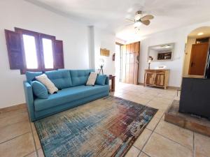 un soggiorno con divano blu e TV di Casa Caballo a private cottage in Lubrin a Lubrín