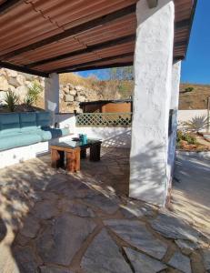 patio con divano blu e tavolo di Casa Caballo a private cottage in Lubrin a Lubrín