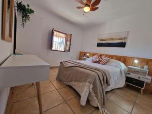 a bedroom with a bed and a ceiling fan at Casa Caballo a private cottage in Lubrin in Lubrín