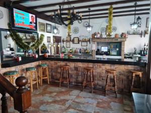 um bar com bancos e um balcão num restaurante em Hostal El Hidalgo em Villaluenga