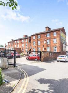 ベッドフォードにあるBedford Town Contractors HQ, Park Your Van, Cosy Sleep, Fast Wifiの大きなレンガ造りの建物で、正面に駐車場があります。