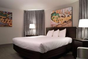 a bedroom with a large bed with white sheets at Fitz Tunica Casino & Hotel, Trademark Collection by Wyndham in Tunica Resorts