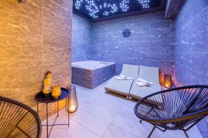 a bathroom with a tub and a bed and chairs at Mamma´s Boutique Hotel in Poděbrady