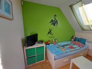 Chatka z Góralskim Klimatem في جيفيتس: غرفة نوم بحائط أخضر مع لاعب كرة قدم على الحائط