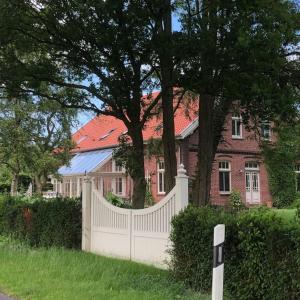 einen weißen Zaun vor einem Haus in der Unterkunft Holzmichl in Varel