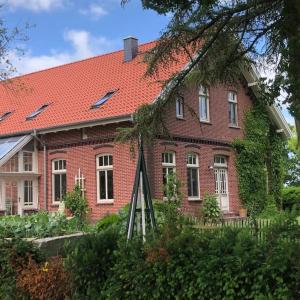 duży dom z czerwonej cegły z czerwonym dachem w obiekcie Holzmichl w mieście Varel