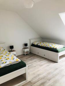 1 Schlafzimmer mit 2 Betten und 2 Nachttischen in der Unterkunft Holzmichl in Varel