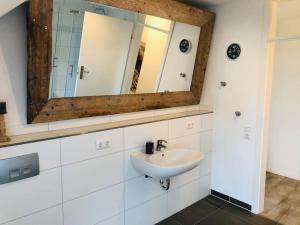 ein Bad mit einem Waschbecken und einem Spiegel in der Unterkunft Holzmichl in Varel