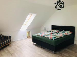 ein Schlafzimmer mit einem Bett mit einer grünen Bettdecke in der Unterkunft Holzmichl in Varel