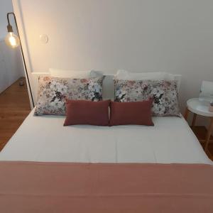 una gran cama blanca con almohadas encima en Formosa Patio with Free Parking, en Oporto