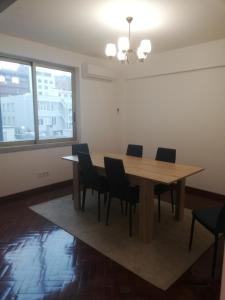 republica83-Lisbonhome في لشبونة: غرفة طعام مع طاولة وكراسي خشبية