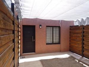 un garaje con dos puertas y una ventana y un edificio en Departamento por calle Chile TUNUYAN en Tunuyán