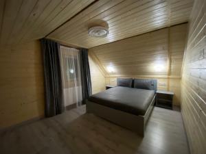 een kleine slaapkamer met een bed in een kamer bij Vienna House in Jaremtsje