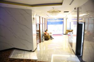 a person sitting in a chair in a lobby at Sky Iconic in Dubai