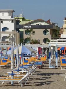 un gruppo di sedie e ombrelloni in spiaggia di Hotel Sorriso - molto più di una stella a Riccione